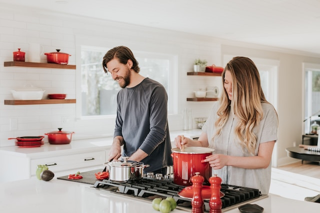 A couple happily preparing a meal in the kitchen