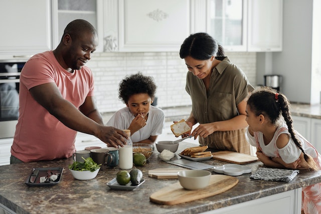 A family of four preparing a meal in the kitchen
