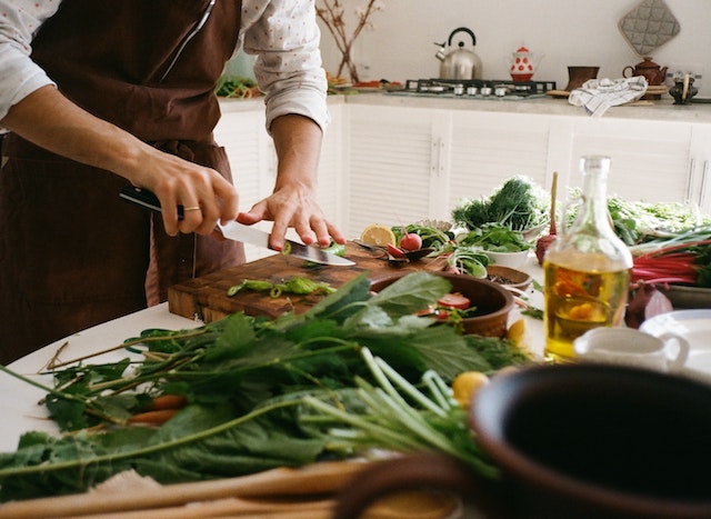Person chopping herbs on a wooden board