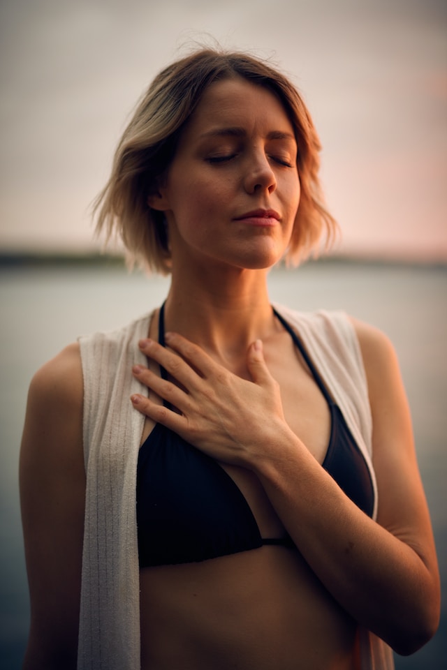 A woman with her hands on her chest seemingly in deep meditation