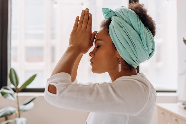 Woman with hands on her forehead in contemplation