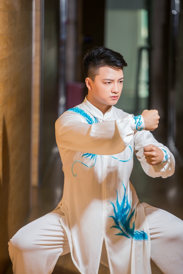 Man in white robes executing a martial arts stance