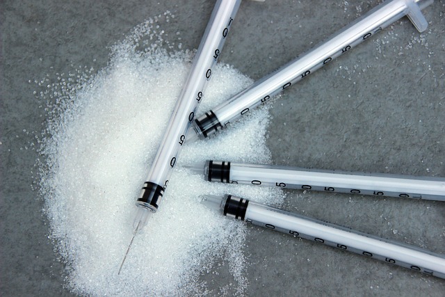 Needle syringes and white sugar on a grey surface