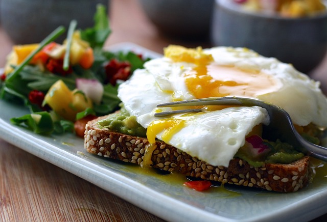Egg on a piece of brown bread with salad on the side