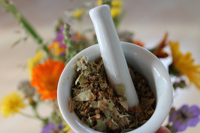Ground dried herbal flowers in a white ceramic mortar and pestle