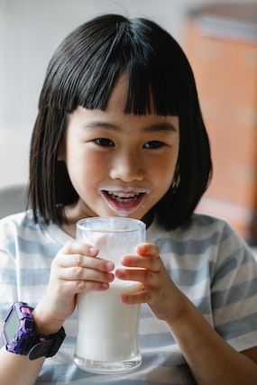 Young girl drinking a glass of milk