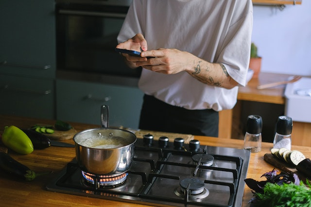 Person taking a picture of dish he is cooking on the stove