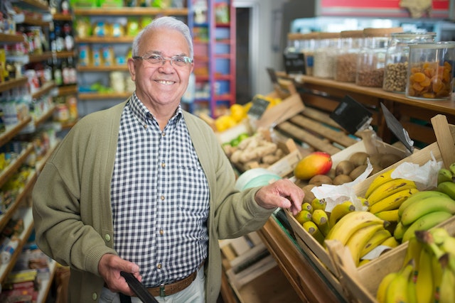 Senior man standing near the fruit displays at a supermarket